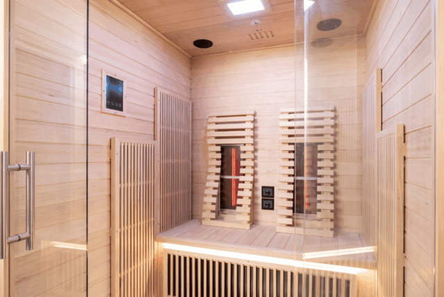 Infrared backrest board glowing warm red at night inside the 2-person red-light sauna
