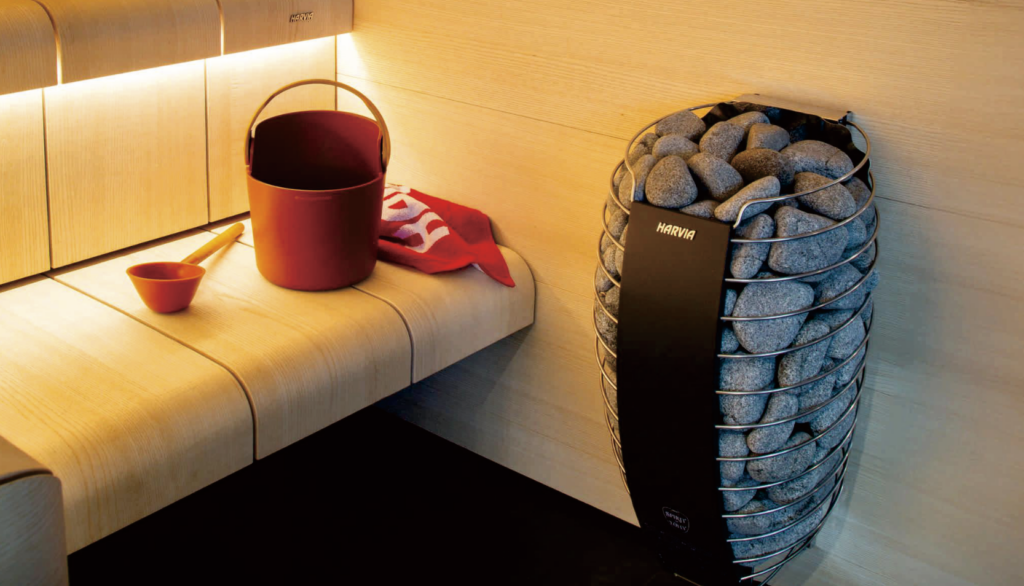 Close-up of a Harvia heater and stones in a warm timber sauna