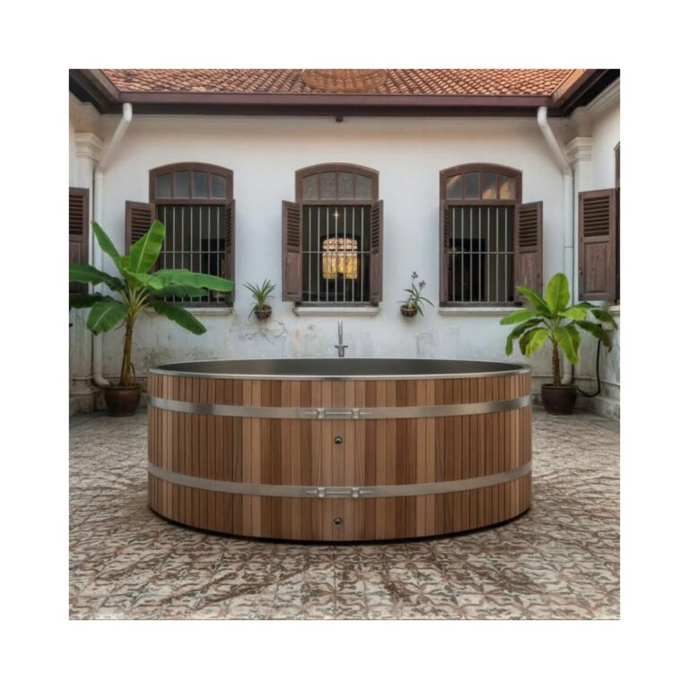 Circular outdoor cold plunge tub with vertical timber slat exterior, stainless steel interior and banding, positioned in a tiled courtyard setting.