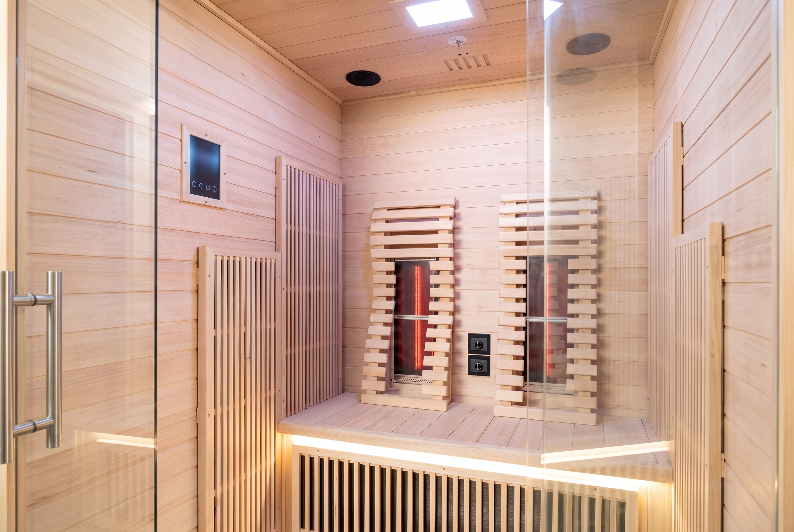 Infrared backrest board glowing warm red at night inside the 2-person red-light sauna